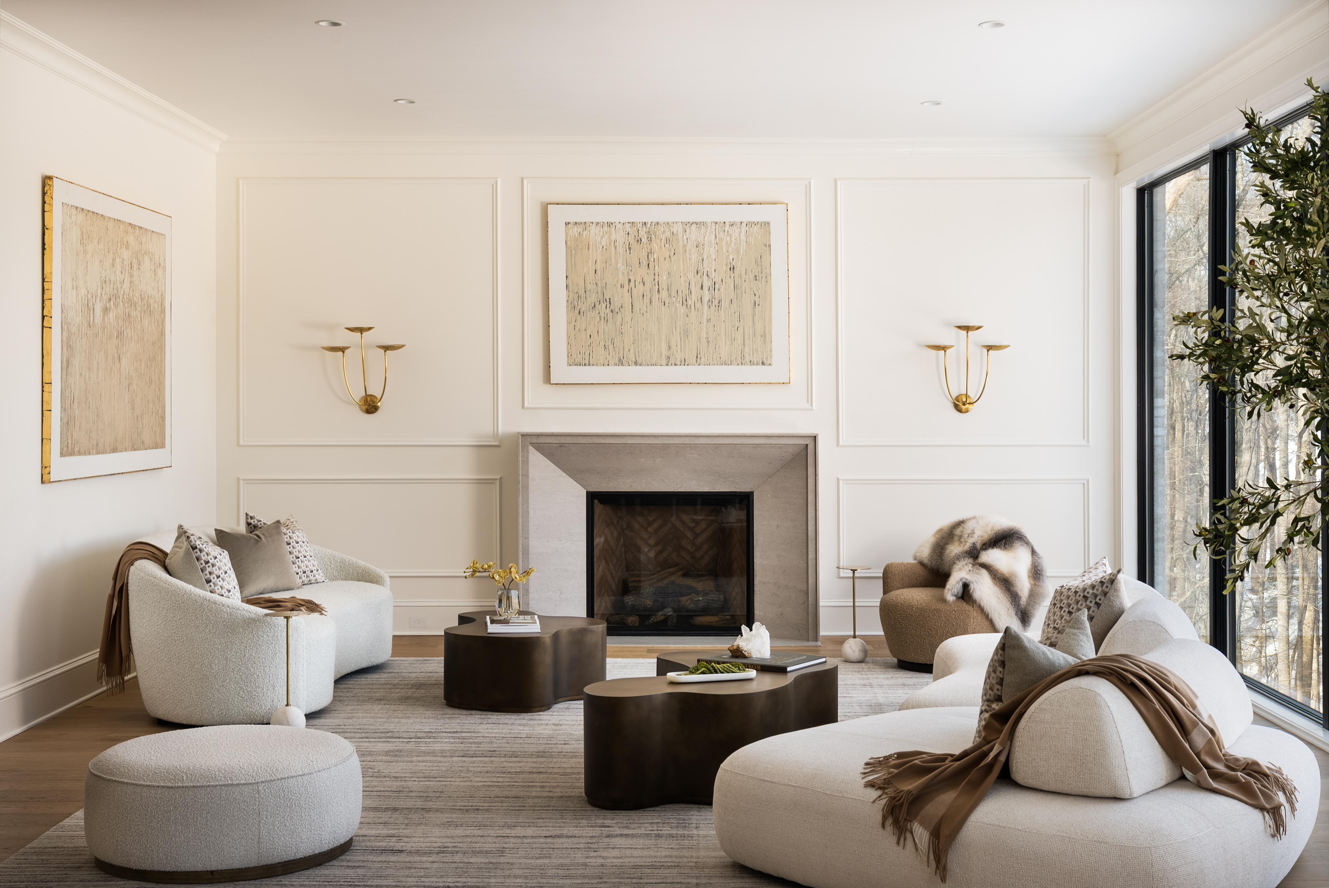 Formal living room with paneled walls, stone fireplace, and curved ivory seating in a McLean custom home