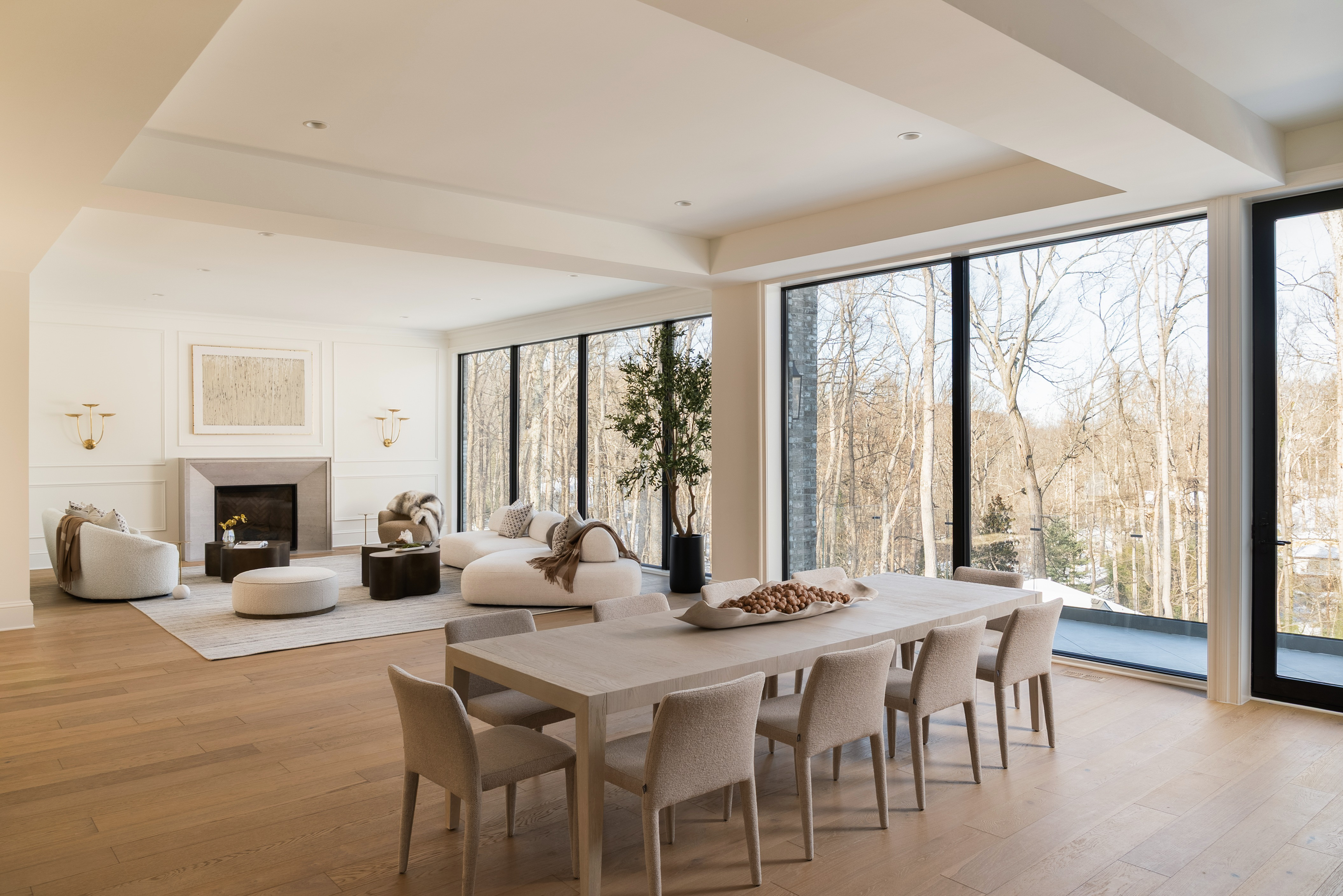 Open-plan dining and living area with ten-seat table, fireplace, and wall-to-wall glass in McLean